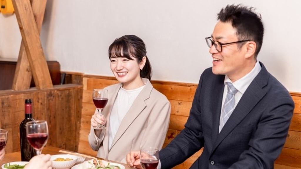接待中、ワインを持って談笑する様子