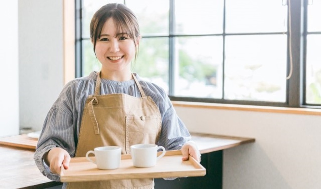 笑顔で働くカフェバイトの女性