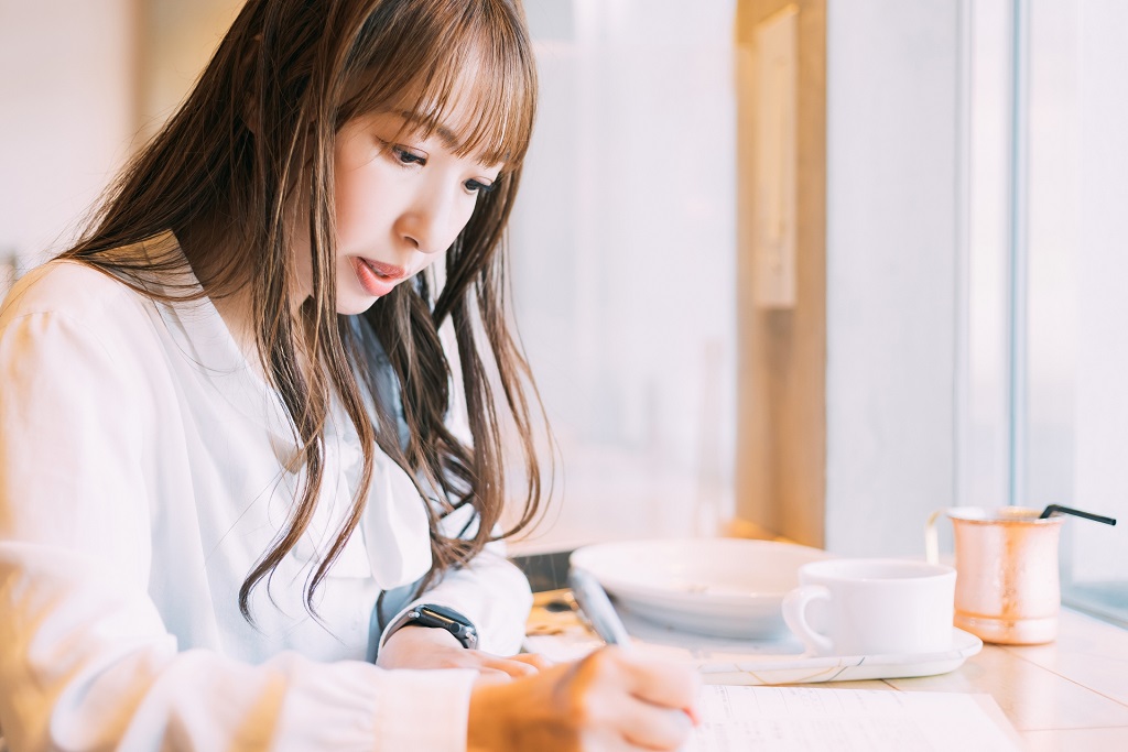 派遣先管理台帳のテンプレート用紙に記入する女性