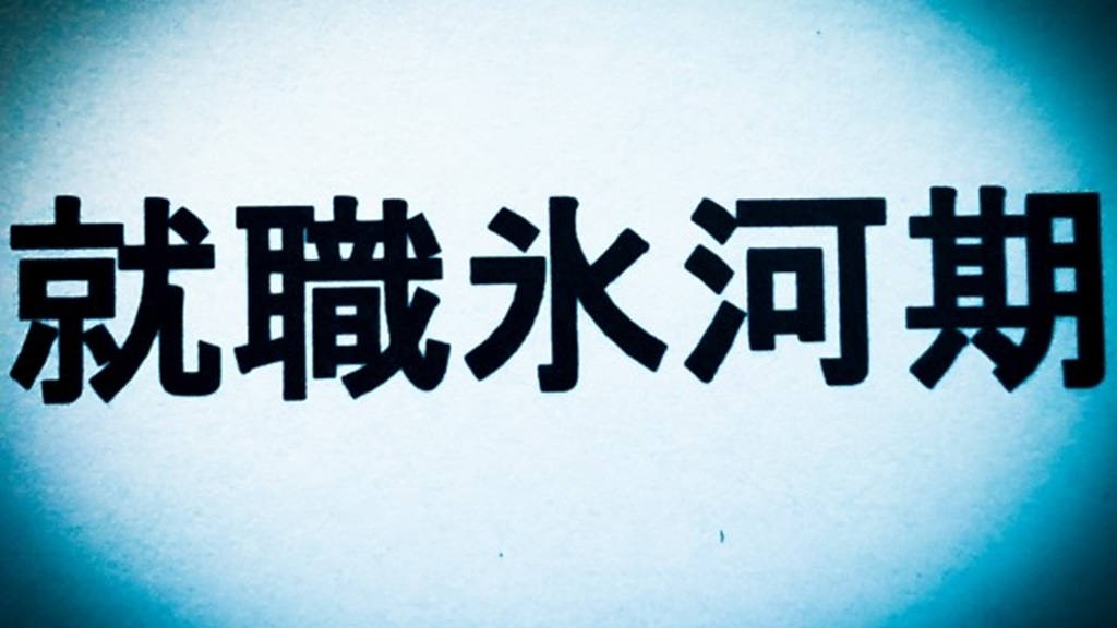 暗いなかで就職氷河期の文字にスポットが当たる様子
