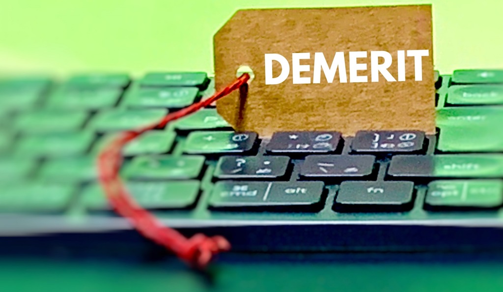 キーボードの上に立てかけられたDEMERITの文字