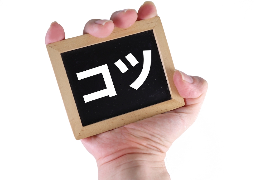 コツと書かれた木材を握りしめる様子