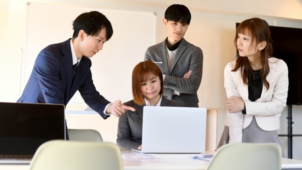 パソコンの画面を前に組織で議論する様子