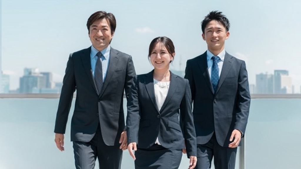 海をバックに歩く人材3名