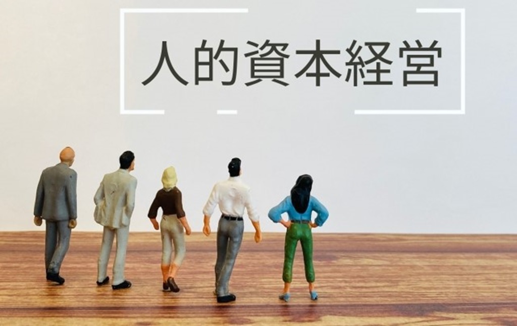 人的資本経営の文字を眺める従業員の様子をミニチュアで表現