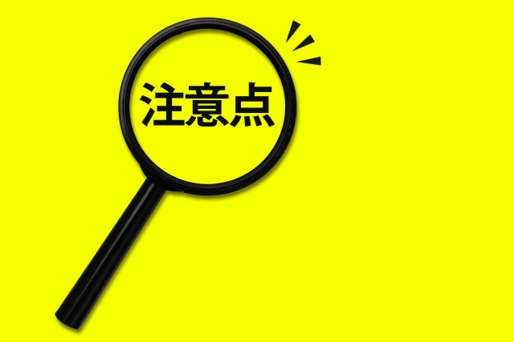 黄色の背景で虫眼鏡に映し出される注意点の文字