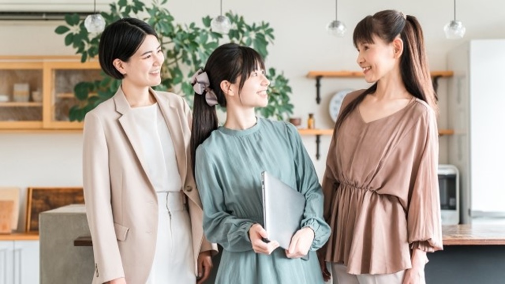 お互いを見合う笑顔の女性スタッフ3名