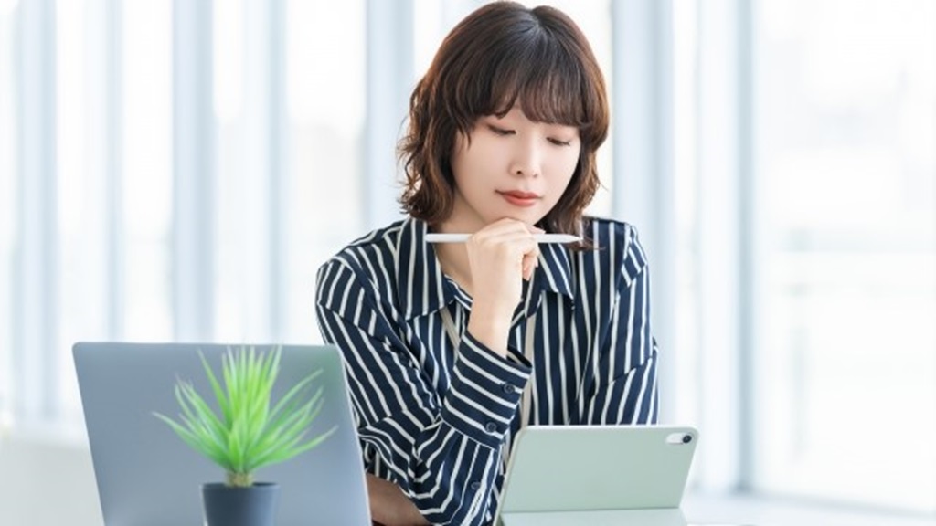 タブレットを見ながら何かを考えている女性