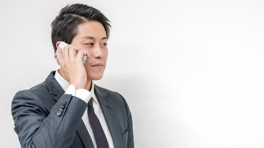 入社日延期の打診を電話で受ける男性担当者の様子