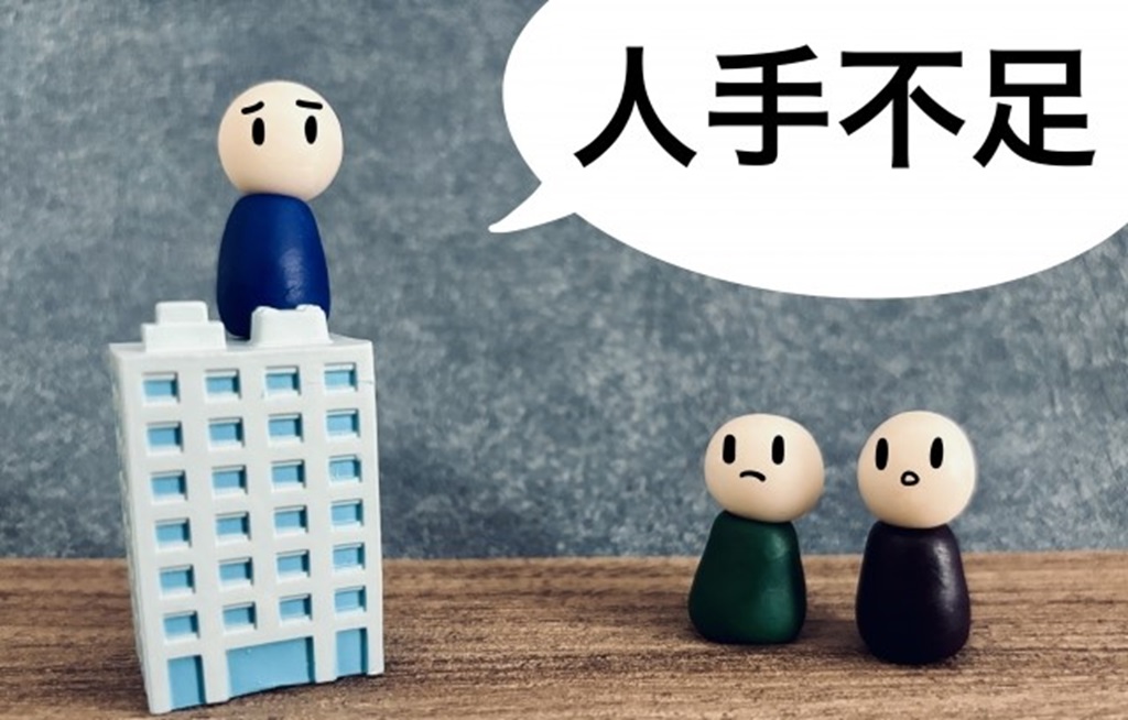 会社のビルと人手不足と書かれた吹き出し