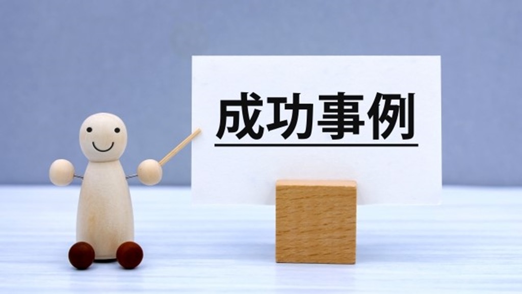成功事例と書かれた紙を指すミニチュア