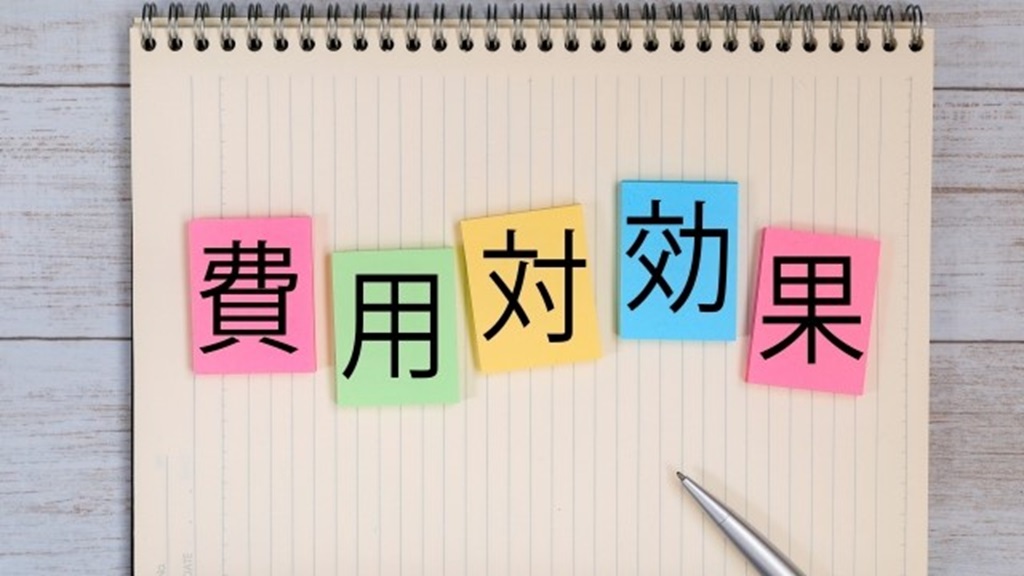 ノートの上に置かれたカラフルな付箋で書かれた費用対効果の文字