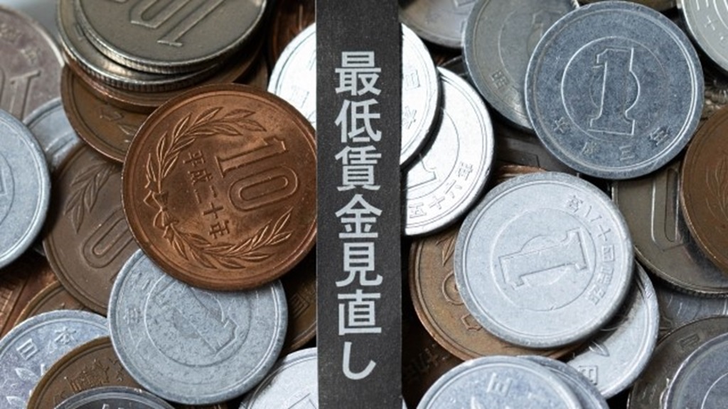 最低賃金見直しの文字と積み重なった小銭