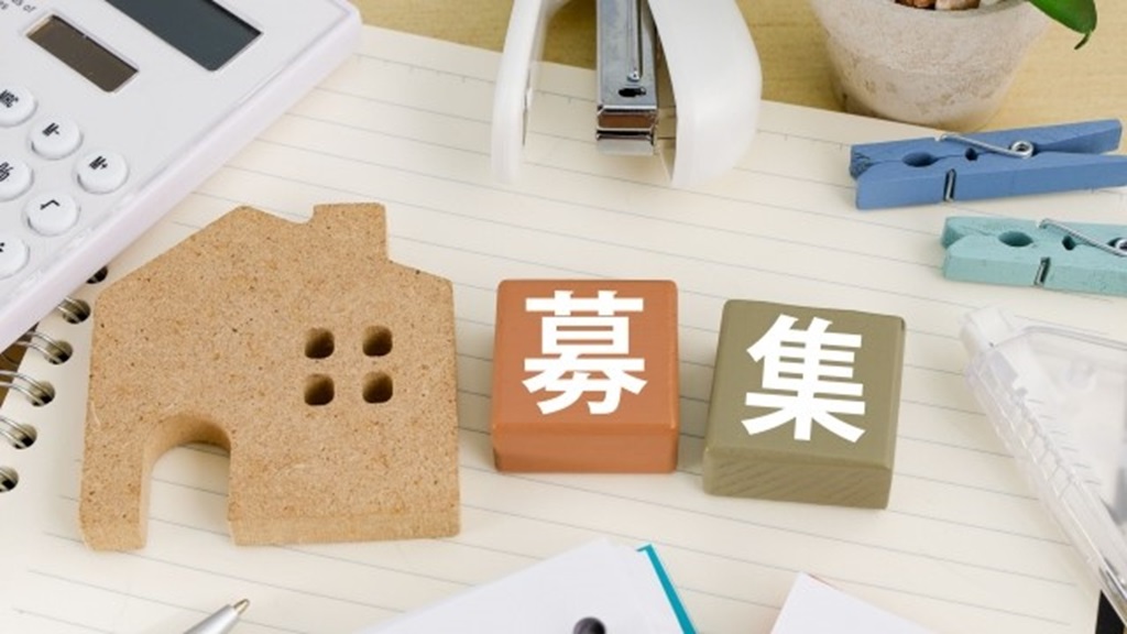 ノートの上に散乱する文房具と募集と書かれたブロック