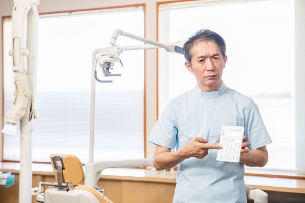 電卓を持つ院長
