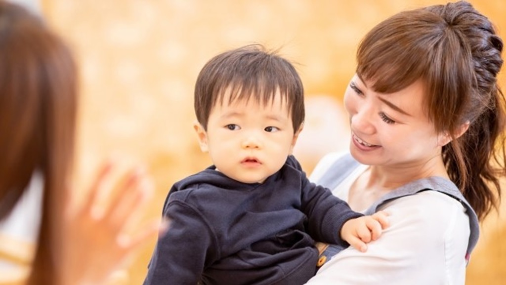 保育士として活躍する女性が子どもを抱っこしている様子