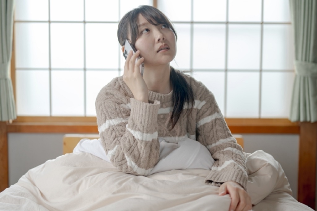 当日欠勤の連絡を入れる女性