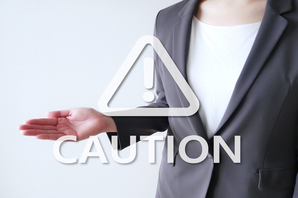 スーツの女性をバックに浮き出るCAUTIONの文字
