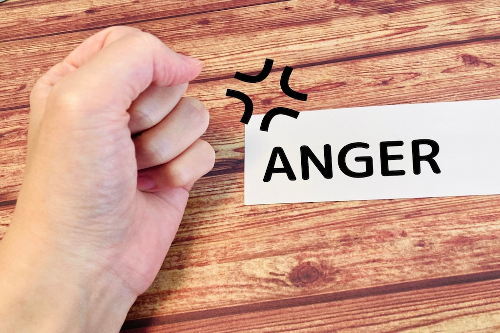 拳と映るANGERの文字