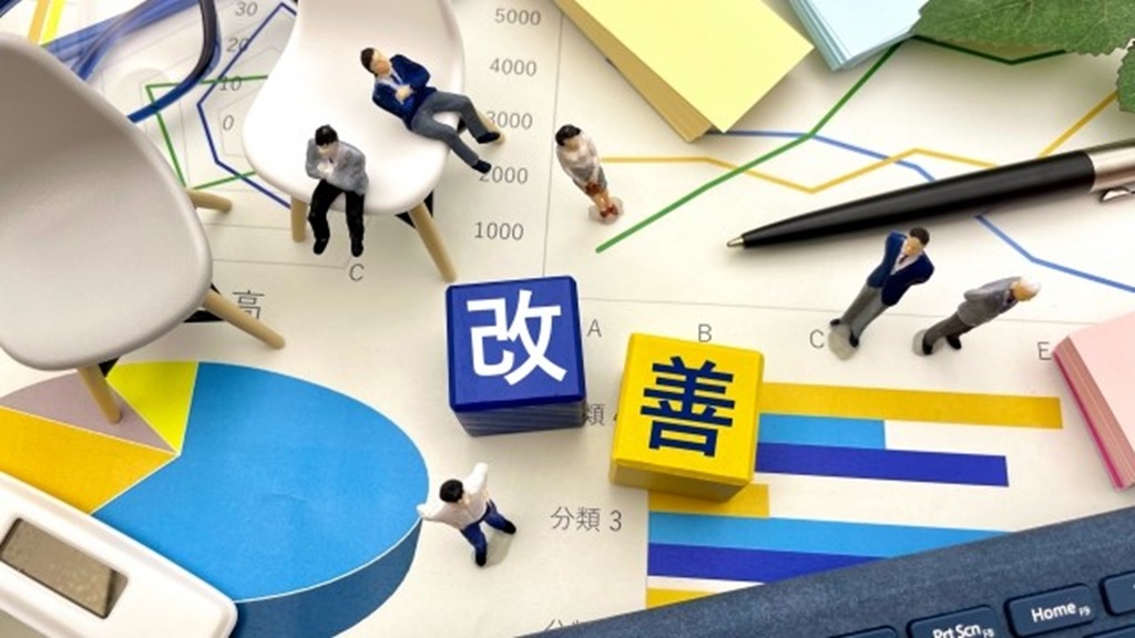 データ資料の上に置かれる改善と書かれたブロック