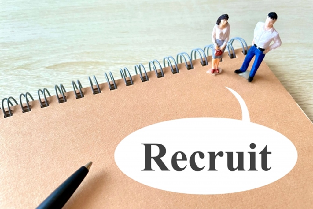 ノートの表紙に書かれたRecruitの文字と粘土で作られた男女