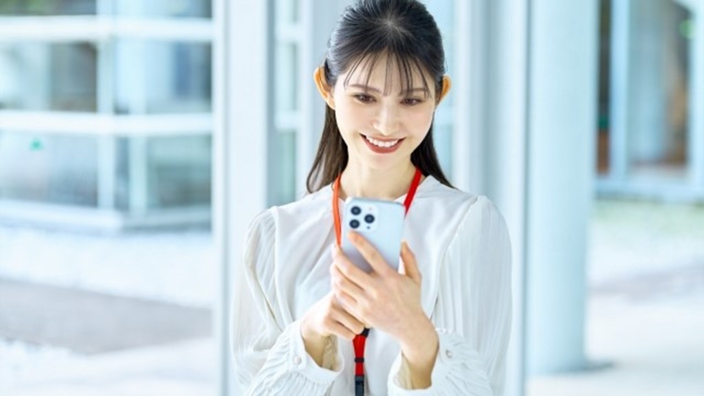 スマホで面接日程に関するメールの返信を読む女性