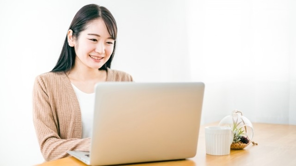 応募者からの返信メールを読み笑顔になる女性