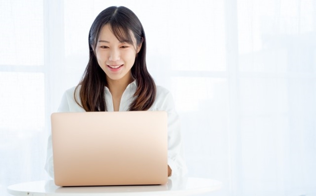 笑顔でメールを送る女性