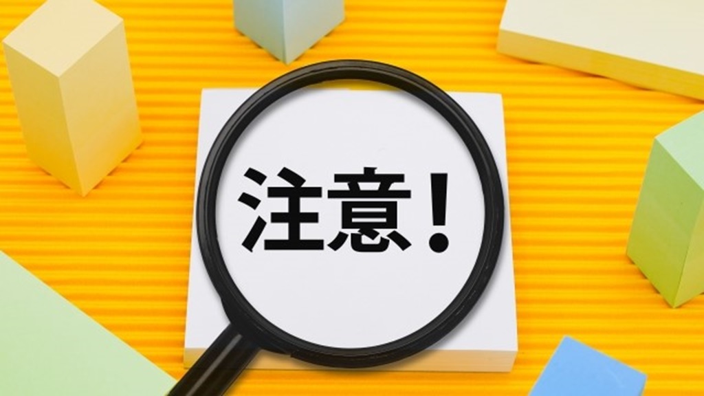 虫眼鏡に映し出される注意の文字