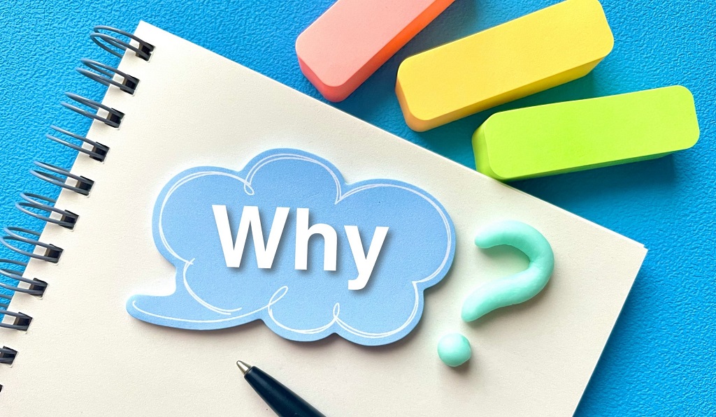 Whyと書かれた画用紙の上の吹き出し