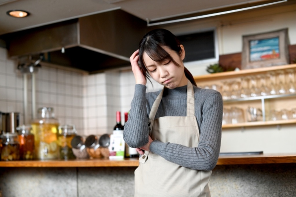 悩んでいる飲食店スタッフの様子