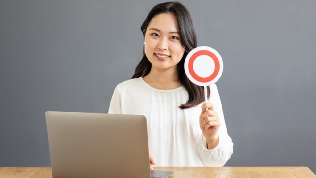 笑顔で正解の札(成功を示唆)を上げる女性