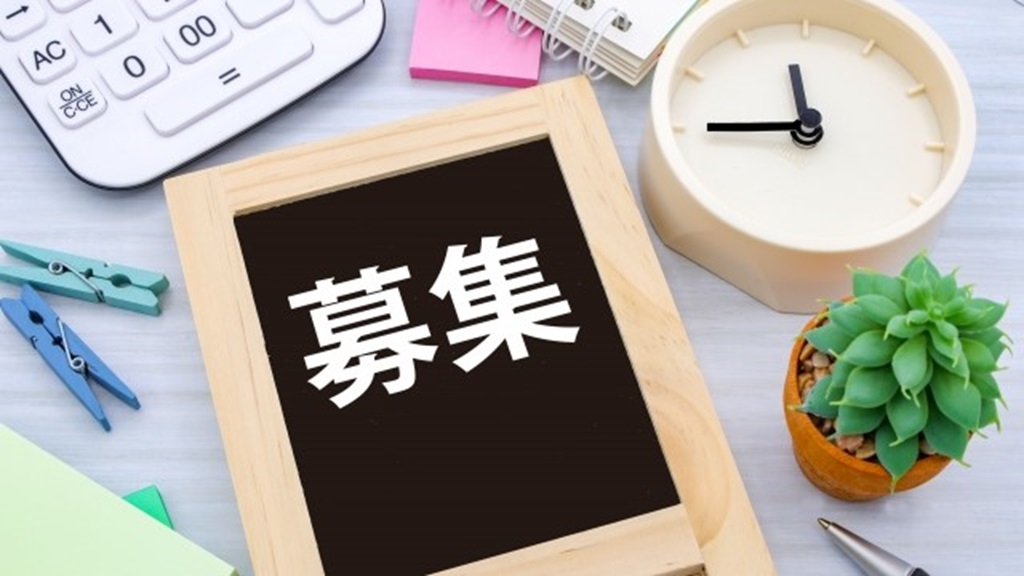 時計、電卓、植物、額縁に収められた募集の文字