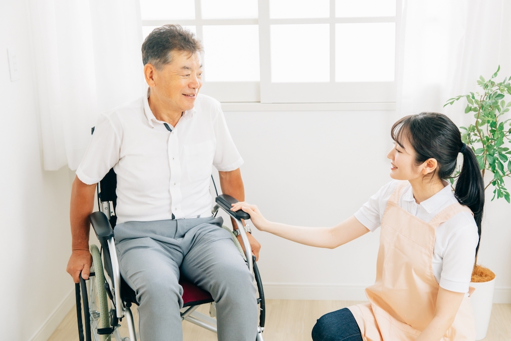 車椅子に乗った高齢者を世話する介護スタッフ