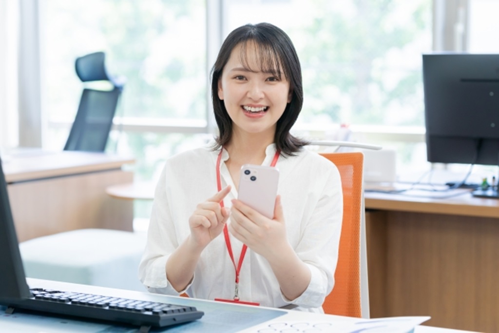 スマートフォンを触っている女性社員